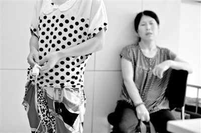 昨日，武建同的妹妹手拿事发时的充电器站在海淀医院ICU病房外，等候哥哥醒来。新京报记者 周岗峰 摄