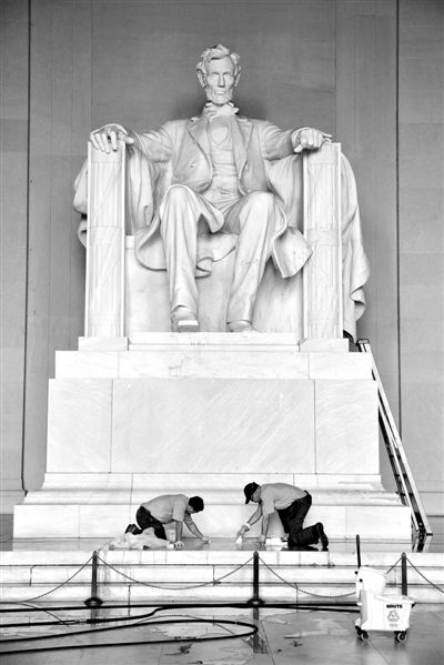 当地时间2013年7月26日，美国华盛顿，美国国家公园工作人员清洗遭泼油漆的林肯纪念堂。林肯纪念堂26日凌晨遭人恶意泼漆，被迫暂时关闭。负责管理公园与纪念建筑的美国公园警察已就此展开调查。